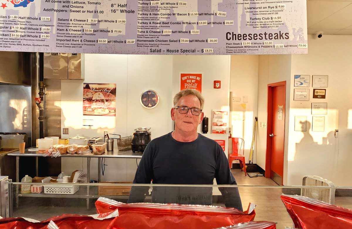 Bob Farlow stands behind his deli counter at Hoagie City